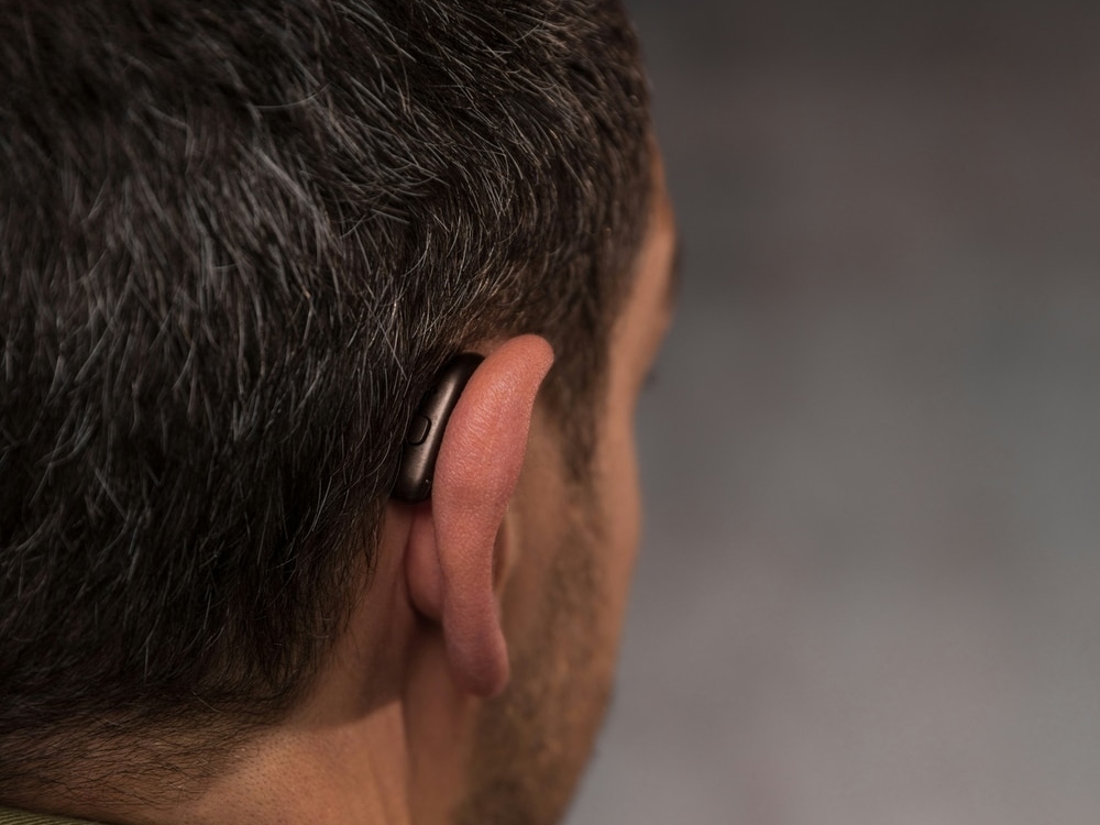 Navy-veteran Doctor of Audiology programming a new hearing aid during a fitting at Precision Hearing in San Antonio, TX