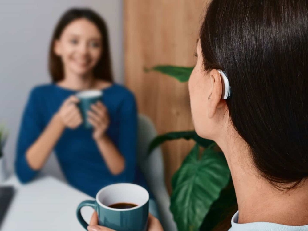Woman wearing a receiver-in-canal hearing aid — one of several hearing aid styles fitted at Precision Hearing in San Antonio, TX